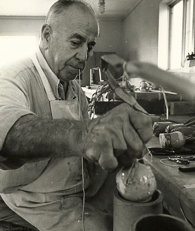 Vintage photo of Vitale Fireworks staff stuffing a fireworks mortar with a fireworks shell