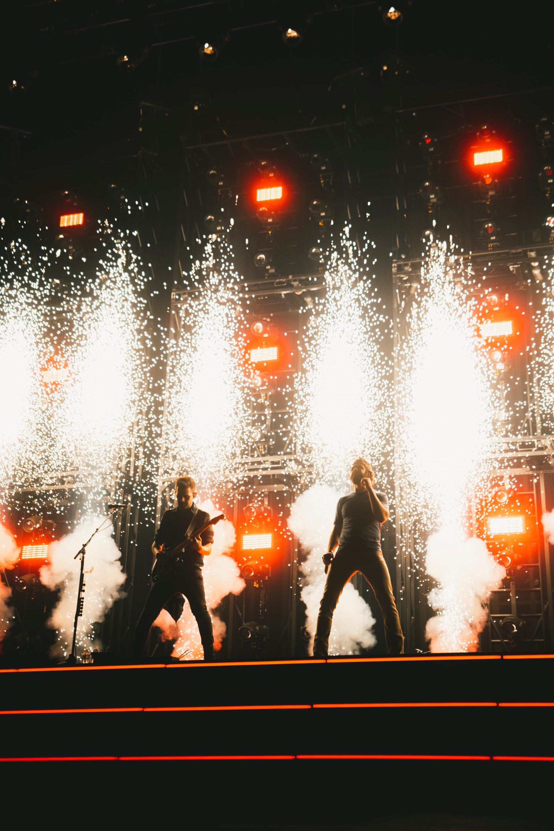 White spark effects erupt in tall columns behind Thomas Rhett and his band during a performance on the Better in Boots Tour.