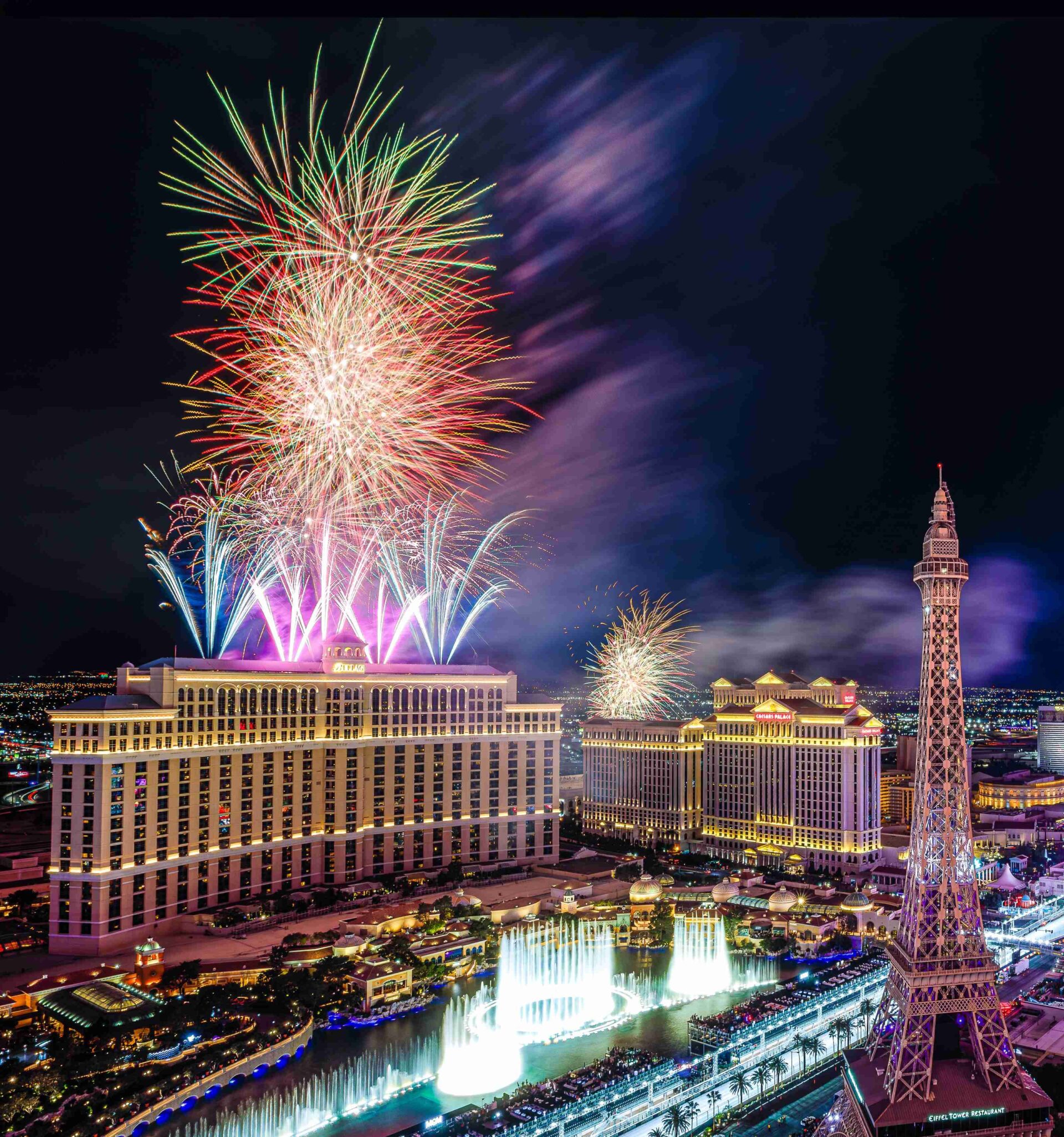 Formula 1 Las Vegas Grand Prix fireworks burst above the Las Vegas Strip hotels and the Eiffel Tower replica at night.