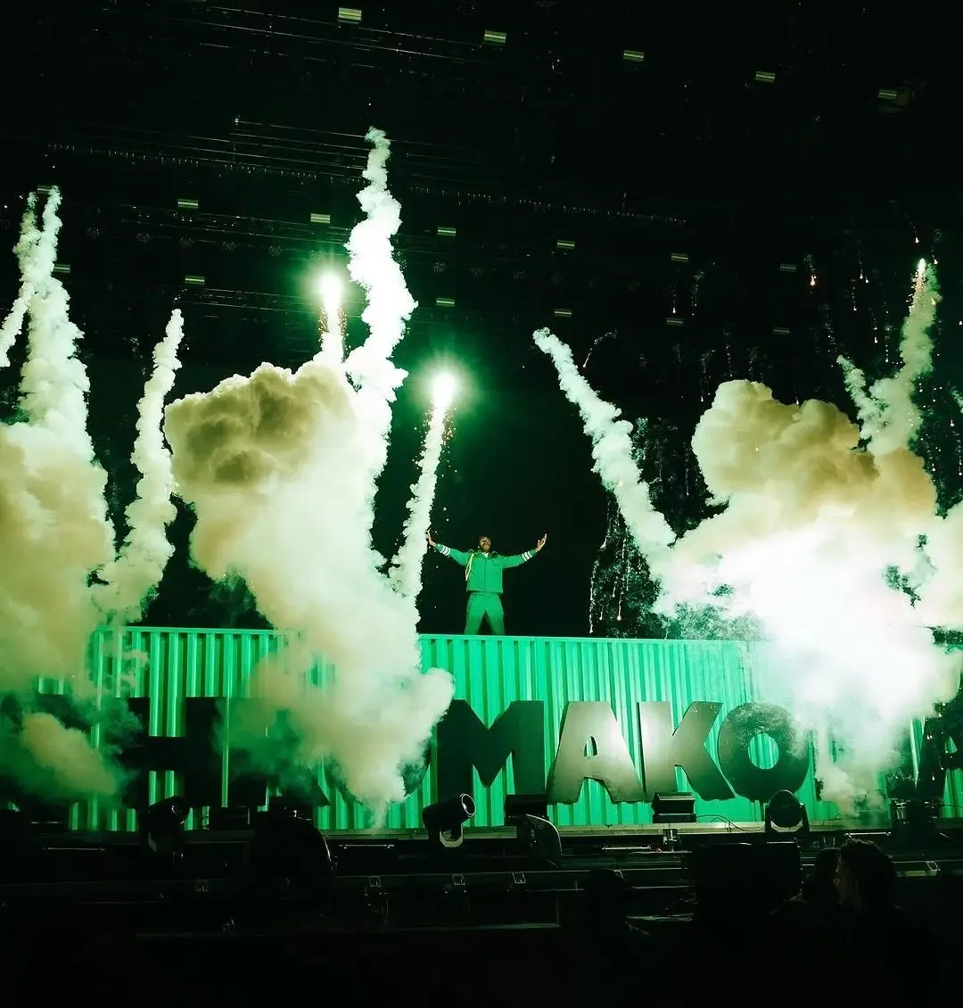 Tyler the Creator stands atop a stage platform as vertical cryo smoke plumes and green spark effects erupt on both sides.
