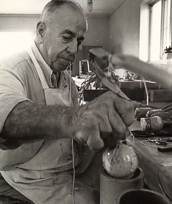 Vintage photo of Vitale Fireworks staff stuffing a fireworks mortar with a fireworks shell